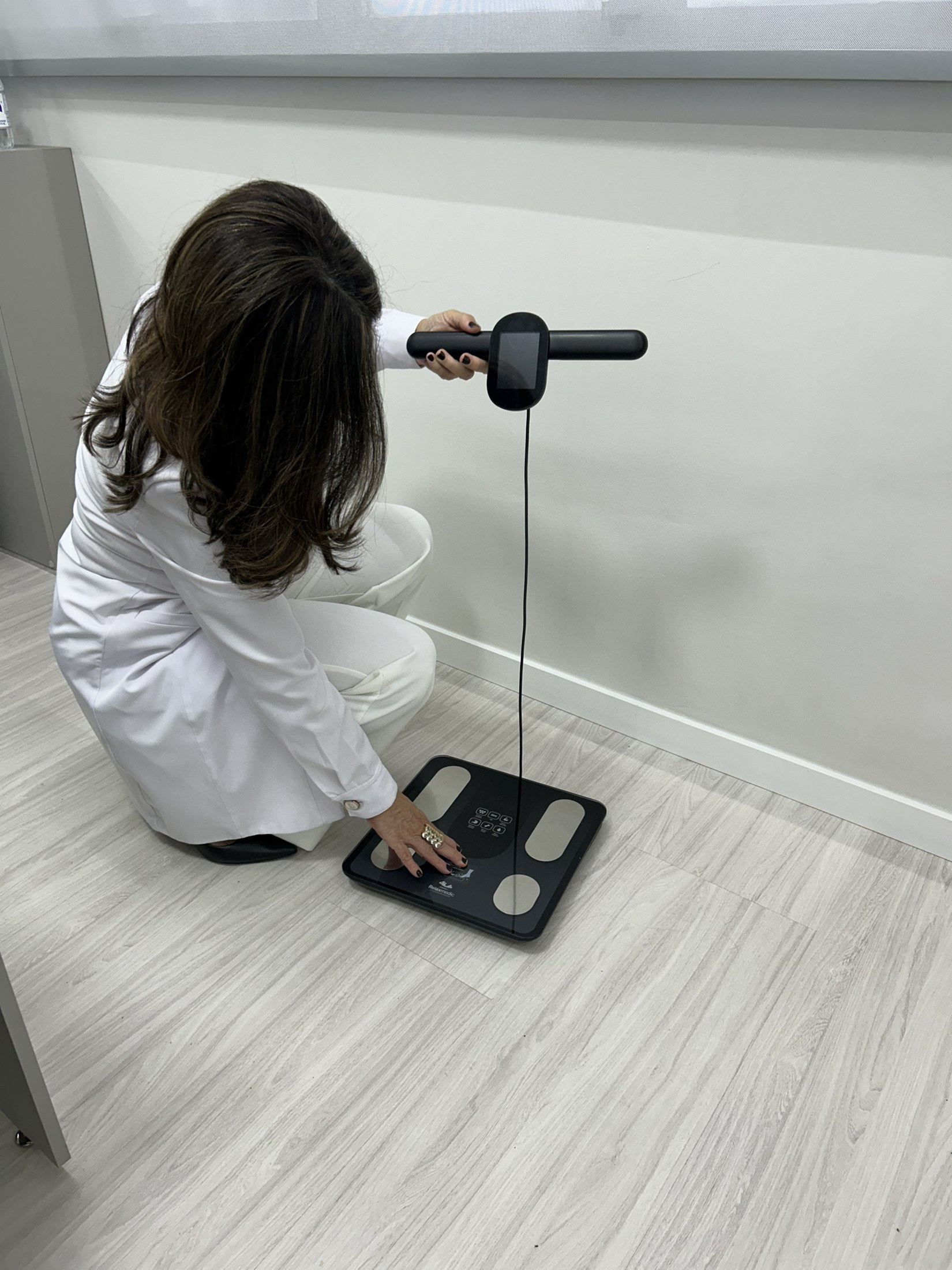 Andréa Malta realizando avaliação de bioimpedância no consultório.