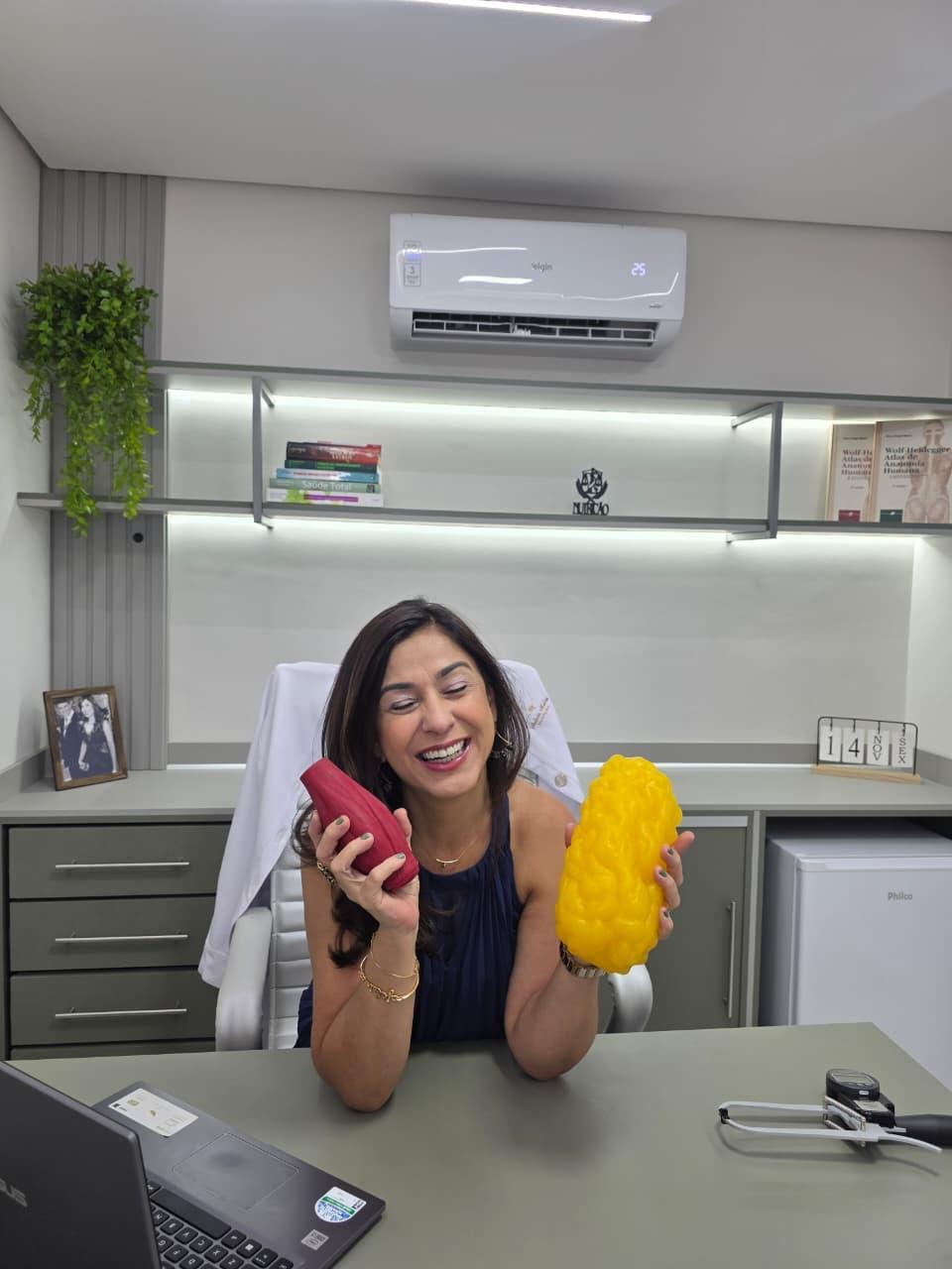 Andréa Malta brincando com duas metades de laranja no consultório.
